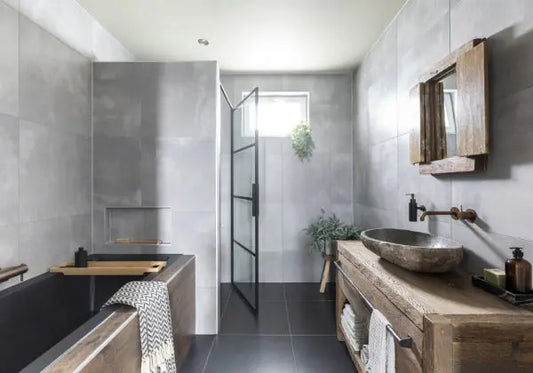 Badkamer inrichten inspiratie: moderne badkamer met grijze tegels, inloopdouche met zwarte glasdeur, bad, houten wastafelmeubel en natuurstenen waskom.