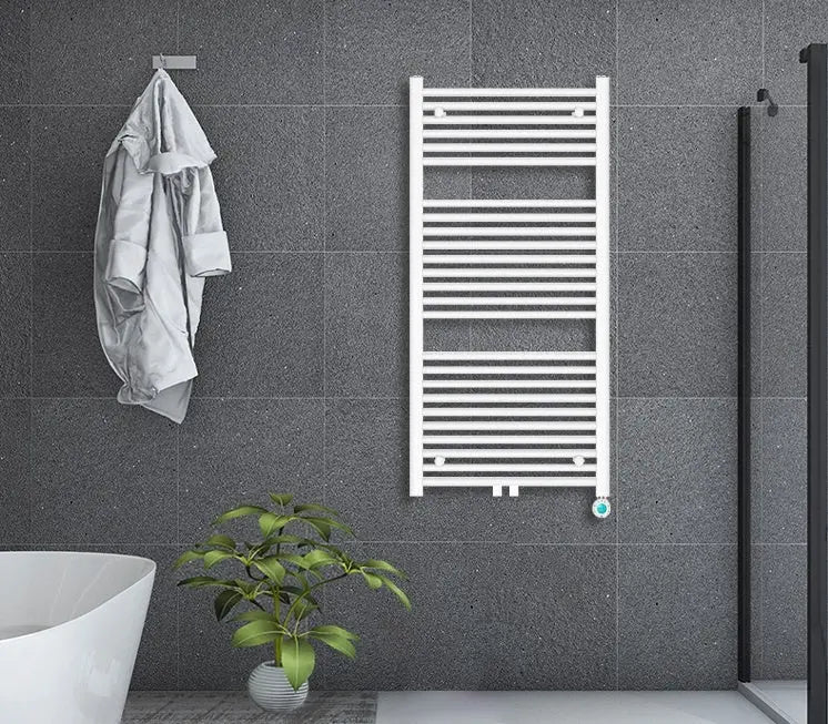 Witte elektrische handdoekradiator aan een donkere badkamerwand naast een bad en douchewand